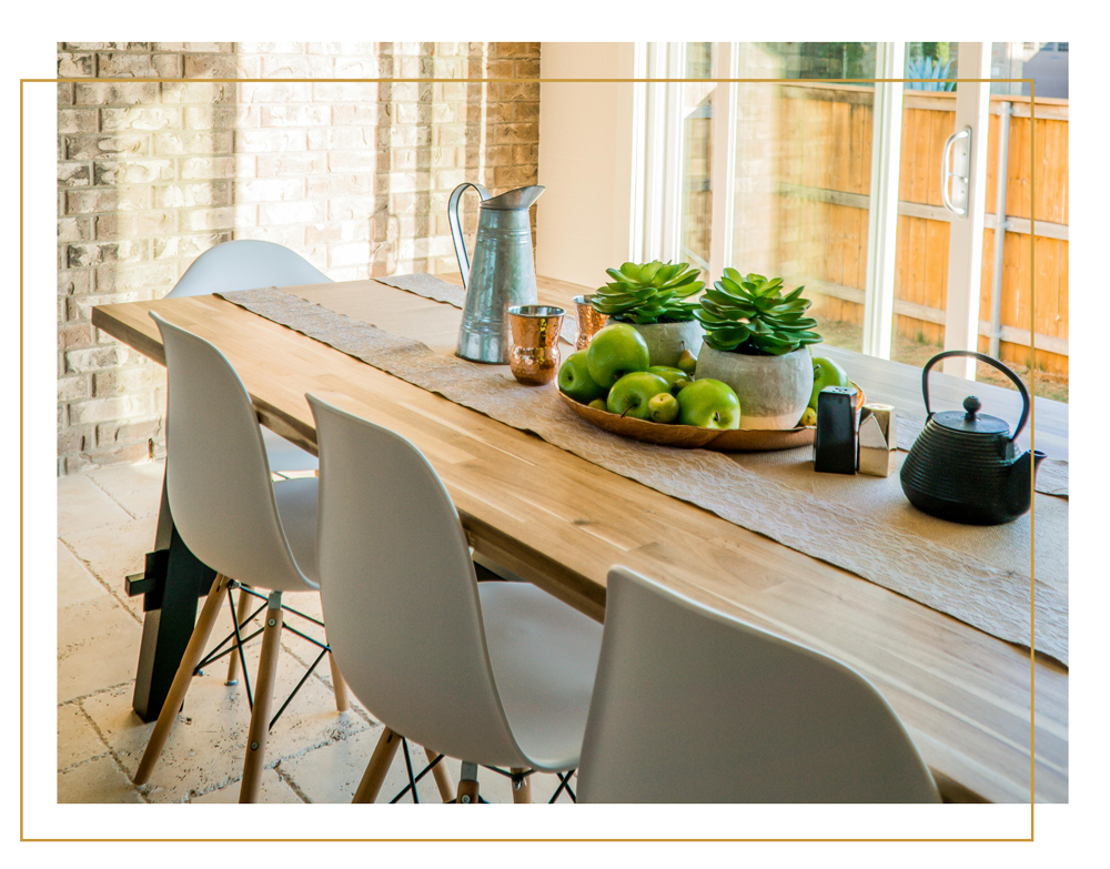 A wooden kitchen dining table in a yellow border.