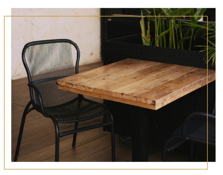 A sustainable rustic wooden table and chair in a yellow border.