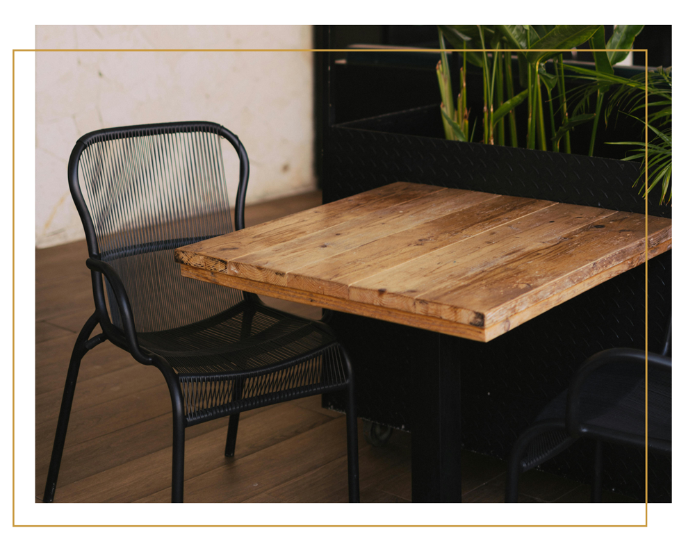 A rustic wooden table and chair in a yellow border.