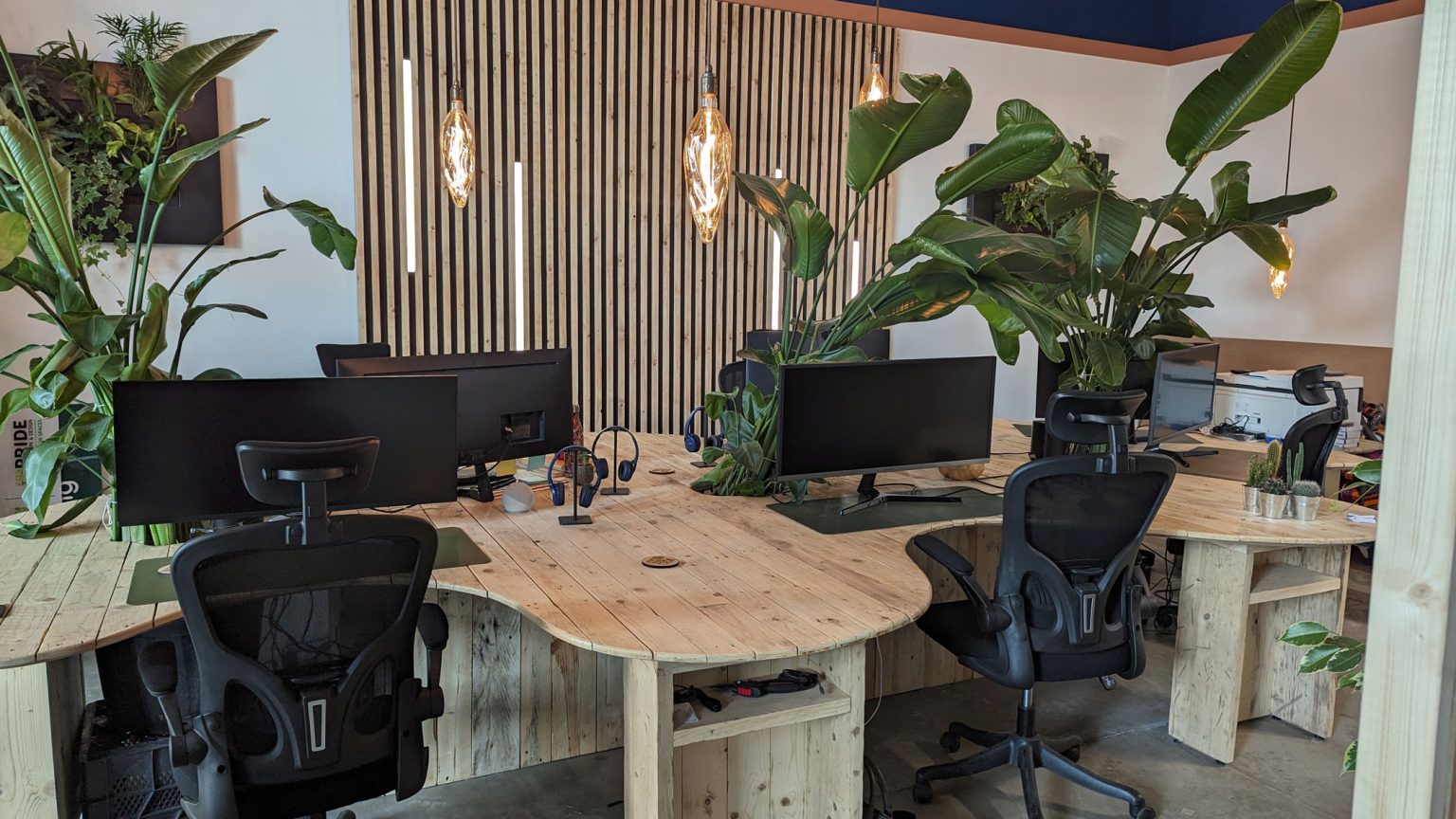 A large office table housing several computers and workspaces, built using sustainable materials by BB design,