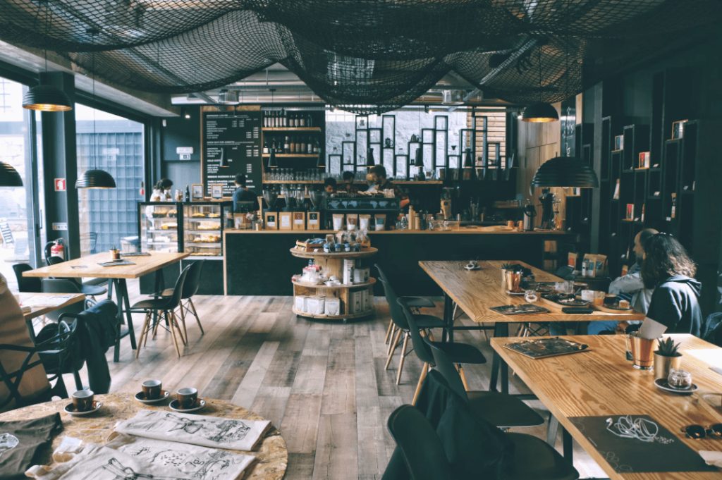 Inside a cafe with wooden table tops and black chairs